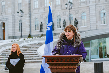 La présidente devant l’hôtel du Parlement lors du 75e anniversaire du drapeau du Québec
